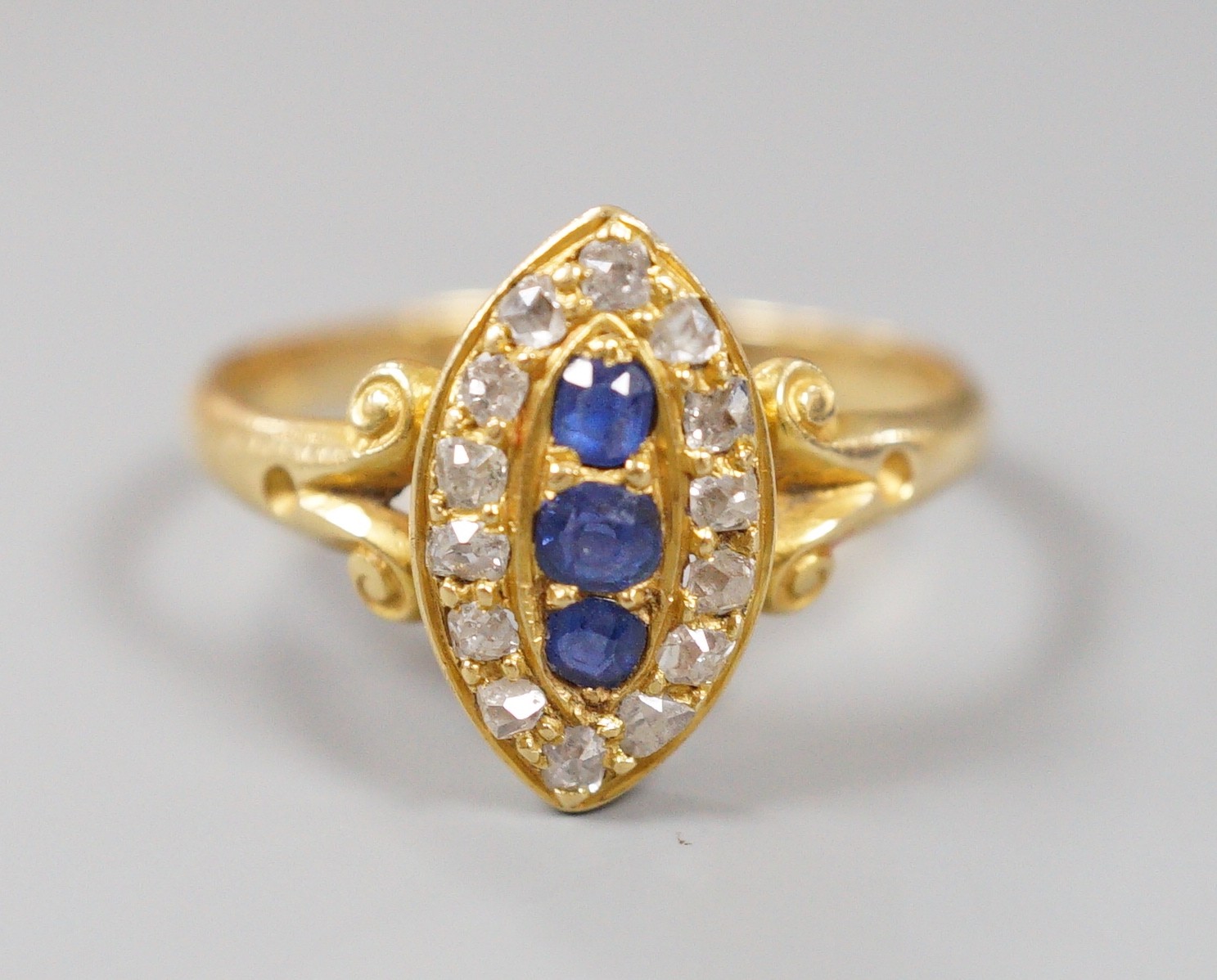 An early 20th century yellow metal, sapphire and diamond set marquise shaped cluster ring, with split shoulders, size R, gross weight 3.1 grams.